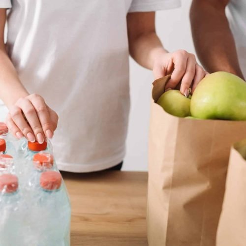 cropped-shot-of-volunteers-with-bags-of-apples-and-water-bottles-on-table-e1657029152531.jpg